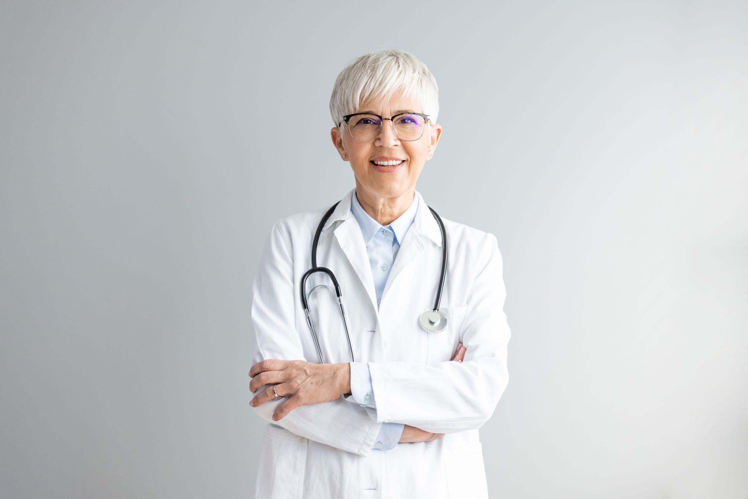 Portrait of confident smiling female doctor. Mature medical professional is wearing lab coat and stethoscope.